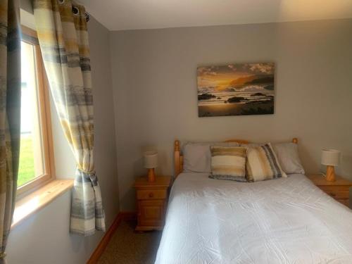 a bedroom with a bed and a window at No 14 Holiday Village House, Sneem, 4 bedrooms in Sneem