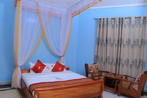 a bedroom with a bed with red pillows at Dreamwood suites Mbarara in Mbarara