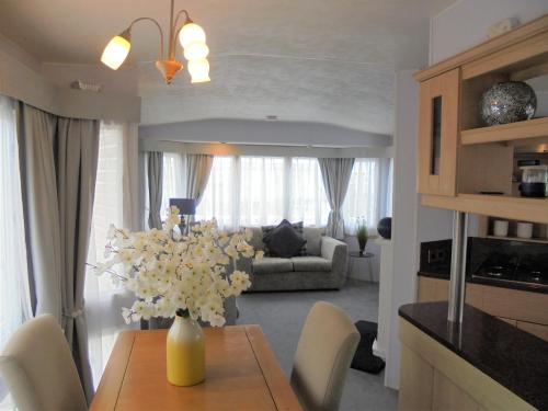 a living room with a vase of flowers on a table at The Chase Topaz Super 4 Berth panel heated Wrap around veranda in Ingoldmells