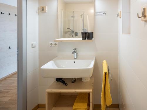 a white bathroom with a sink and a mirror at Vintlerhof in Bressanone