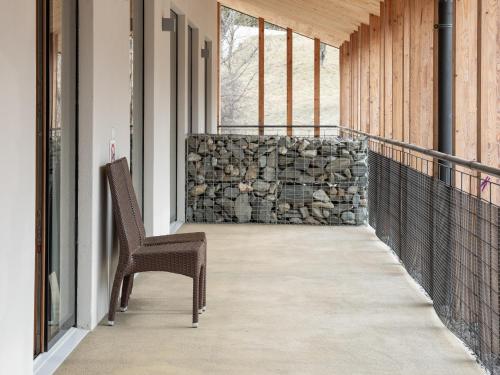a balcony with a chair and a stone wall at Vintlerhof in Bressanone