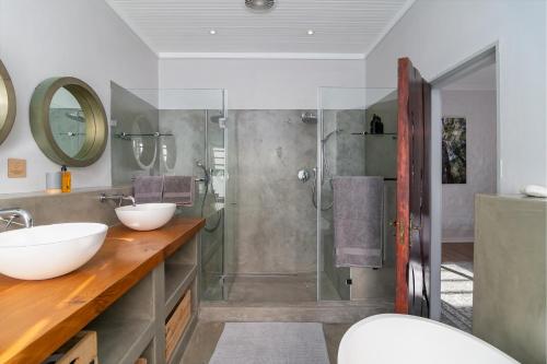a bathroom with two sinks and a shower at In Toto Retreat - Garden Route in Sedgefield