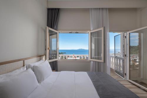 a bedroom with a bed with a view of the ocean at Casa Bloo 360, Adults Only in Kalogria