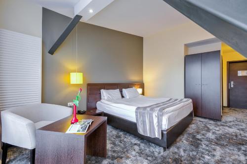 a hotel room with a bed and a couch at Golden Time Hotel in Braşov
