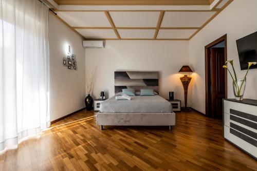 a bedroom with a bed and a wooden floor at I Barcaioli in Giardini Naxos