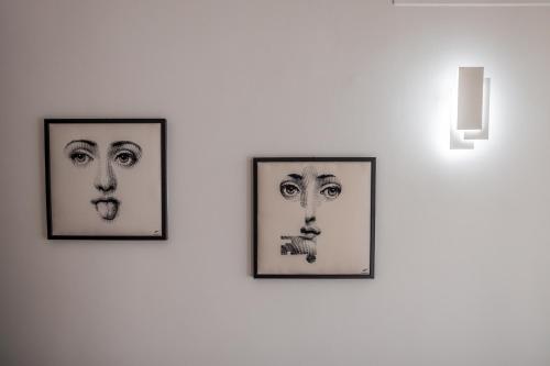 deux images encadrées de visages sur un mur dans l'établissement I Barcaioli, à Giardini Naxos