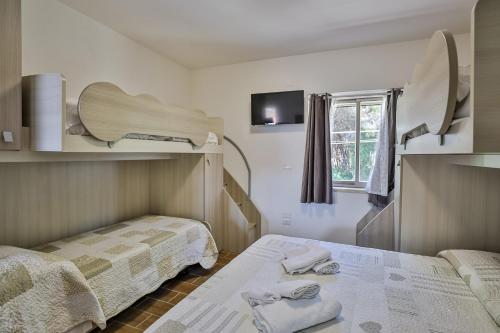 a hotel room with two beds and a tv at Il Pineto Paestum Food & Rooms in Paestum