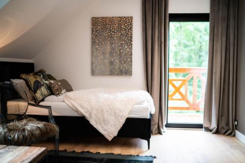 a bedroom with a bed and a sliding glass door at Mały Bór in Lgiń