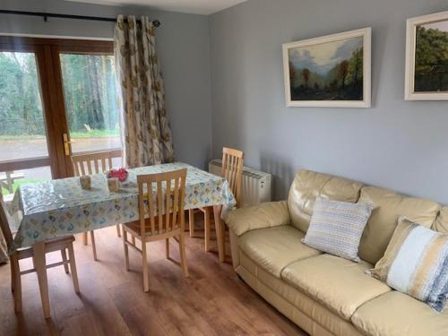 a living room with a couch and a table at No 14 Holiday Village House, Sneem, 4 bedrooms in Sneem