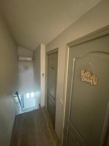 a hallway with a door with a sign that reads smiles banks at Cocooning chez Sabine in Lavilledieu
