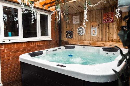 a jacuzzi tub in a house with two windows at Elegant 2 bed with hot tub and a host of amenities in Liverpool