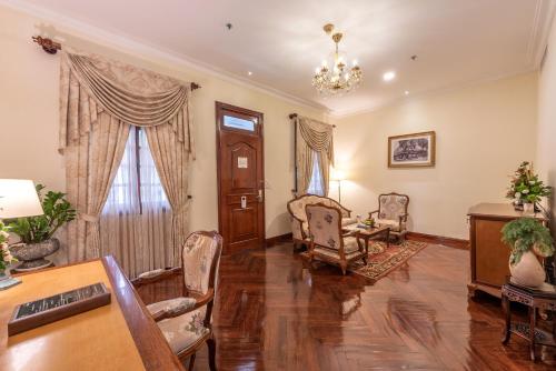 a living room with a table and chairs at Hotel Grand Saigon in Ho Chi Minh City