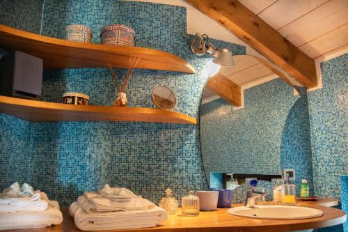 a bathroom with a sink and blue tiles at Il Gomitolo in Biella