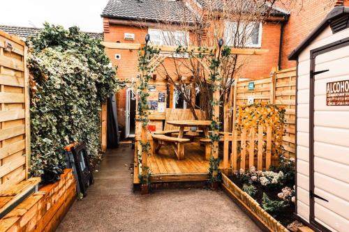 a patio with a wooden table and a wooden fence at Elegant 2 bed with hot tub and a host of amenities in Liverpool