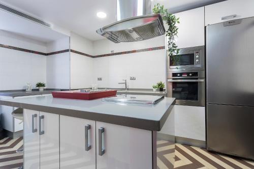 kuchnia z białymi szafkami i czerwonym zlewem w obiekcie Vistas Montealto Amplio 3 rooms 2 baños w mieście Jerez de la Frontera