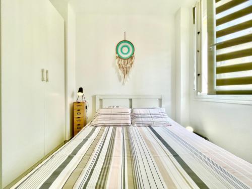 - une chambre avec un lit et une horloge murale dans l'établissement U Paradisu - Balcon - 100m mer - Parking - Climatisation, à Propriano
