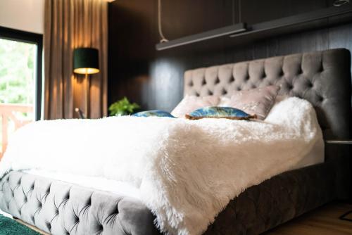 a bed with a white blanket and pillows on it at Mały Bór in Lgiń