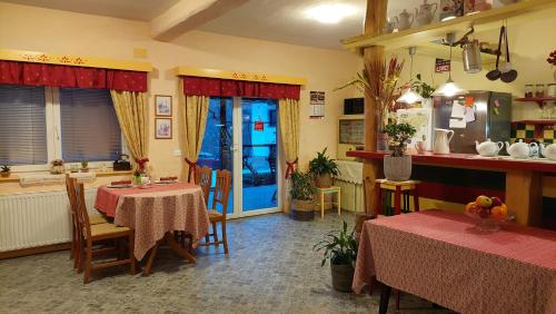 a dining room with two tables and a kitchen at Rooms Ravnik in Bled