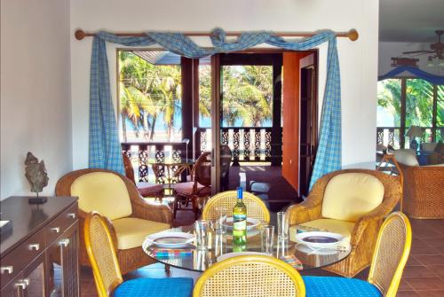 a dining room with a table and chairs and a balcony at Villa Espana in Sam Roi Yot
