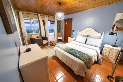 sypialnia z łóżkiem i biurkiem w pokoju w obiekcie PineHouse w mieście Curral das Freiras