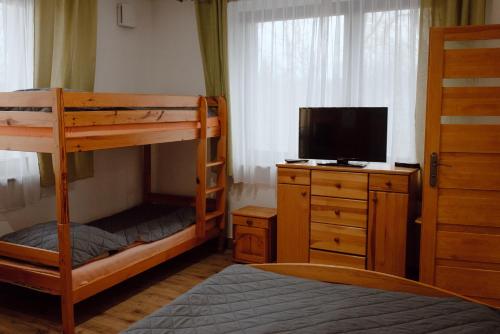 um quarto com dois beliches e uma televisão em Willa Cicha em Rabka