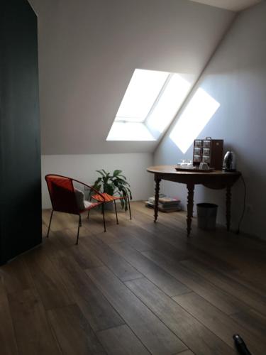 a room with a table and a chair and a skylight at La Malvrais in Janzé