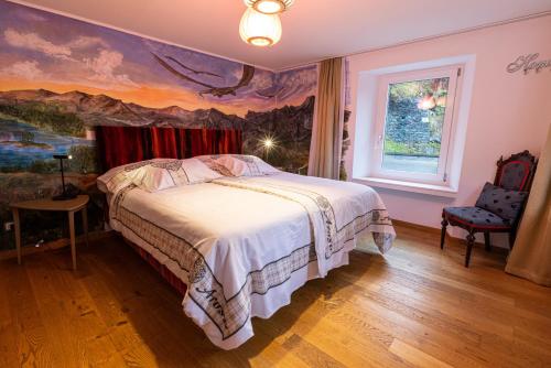 a bedroom with a bed with a painting on the wall at Home Hotel Arosa in Arosa