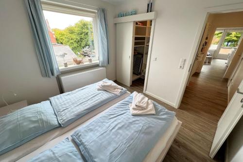 1 Schlafzimmer mit 2 Betten und einem großen Fenster in der Unterkunft Whg Lütt Lee Sandwall 60 Wyk in Wyk auf Föhr