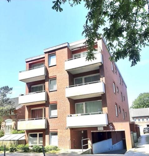 ein großes Backsteingebäude mit Balkonen auf einer Straße in der Unterkunft Whg Lütt Lee Sandwall 60 Wyk in Wyk auf Föhr