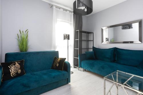 salon z niebieską kanapą i szklanym stołem w obiekcie Margaret Apartment w Krakowie