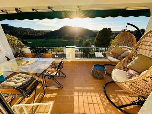 a patio with wicker chairs and a table on a balcony at FLAT Surrounded by Nature WIFI & Pool & beach Nearby in Son Parc