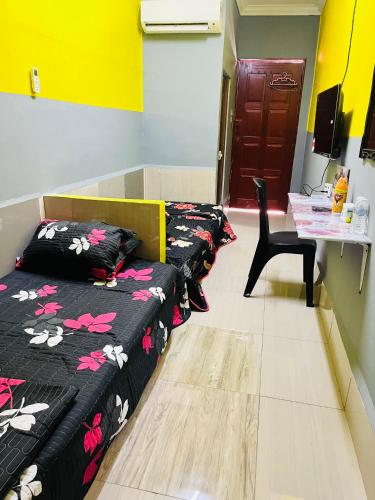 a room with three beds and a table and a table at Homestay/Bilik Teluk Gading in Kuala Rompin