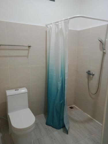 a bathroom with a shower curtain and a toilet at La Grace in Ungasan