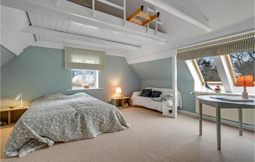 a bedroom with a bed and a table and windows at Awesome Home In Sams With Wifi in Nordby
