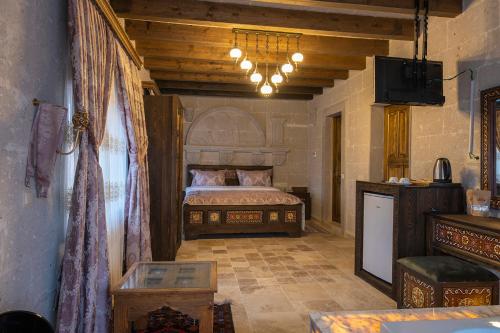 a bedroom with a bed and a television in a room at Underground Cave Suites Hotel in Goreme