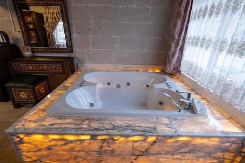 a large bath tub in a room with a window at Underground Cave Suites Hotel in Goreme