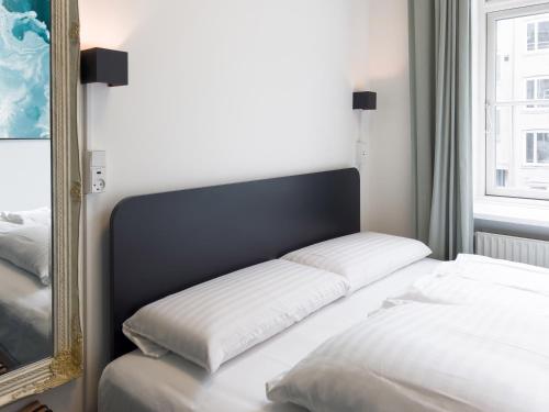 a bed in a room with a mirror at where to sleep in Copenhagen