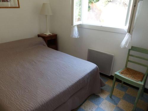 una camera con un letto e una sedia e una finestra di Appartement Le Lavandou, 3 pièces, 4 personnes - FR-1-308-25 a Le Lavandou