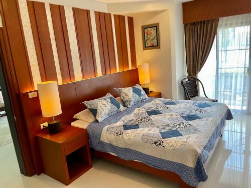 - une chambre avec un lit, deux lampes et une fenêtre dans l'établissement Lakeside Allamanda Apartment, à Bang Tao Beach