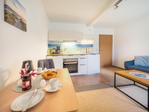 a kitchen and living room with a wooden table and chairs at Gut Vorwerk in Sagard