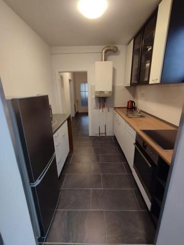 una cucina con frigorifero nero e armadietti bianchi di MK Apartments Bremen 4 a Brema