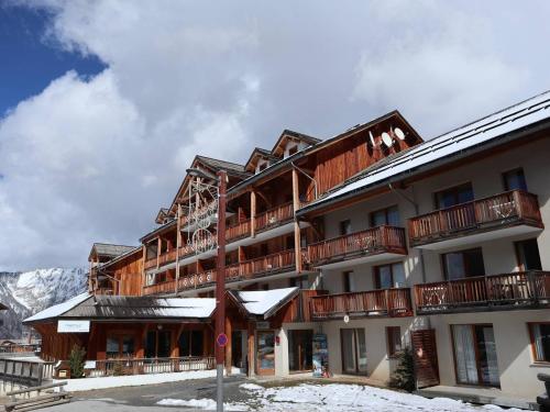 un grand bâtiment avec de la neige au sol dans l'établissement Appartement 4 pers, piscine, jacuzzi & skis aux pieds - Les Orres - FR-1-322-425, aux Orres