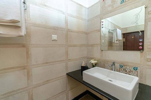 a bathroom with a sink and a mirror at Misty Barn - "Your Poolside Escape Awaits" in Chikmagalur