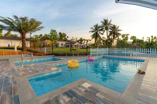 a swimming pool with an inflatable raft in a yard at Misty Barn - "Your Poolside Escape Awaits" in Chikmagalur