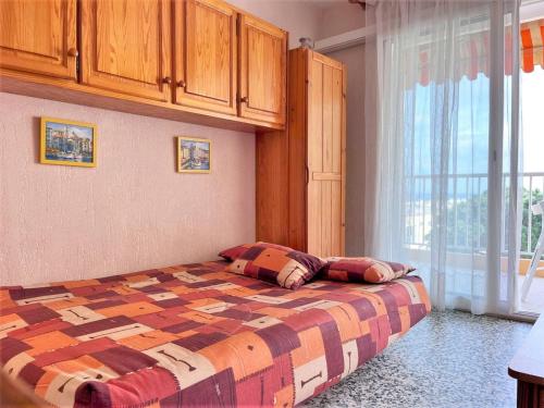 ein Schlafzimmer mit einem Bett mit zwei Kissen darauf in der Unterkunft Appartement Le Lavandou, 1 pièce, 4 personnes - FR-1-251-481 in Le Lavandou