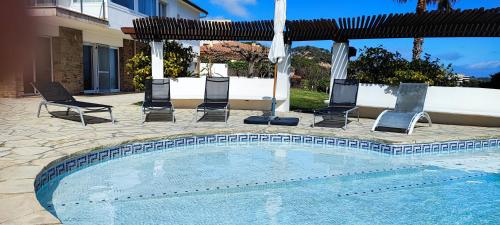 einen Pool mit Stühlen und einem Sonnenschirm in der Unterkunft Els Ametllers luxury apartment Lloguer3.0 in Sant Feliu de Guixols