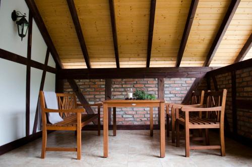 stół i krzesła w pokoju z ceglaną ścianą w obiekcie Nadmorska Strzecha w Smołdzińskim Lesie