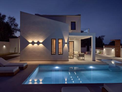 a villa with a swimming pool at night at Estelle Luxury House in Zakynthos Town