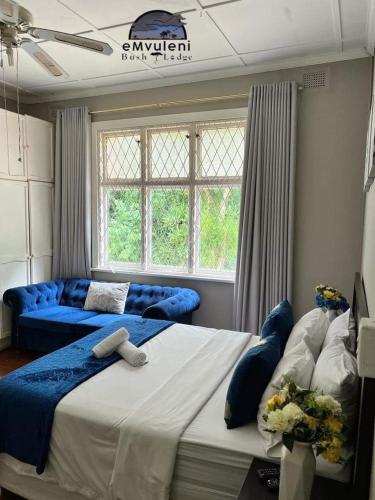 sypialnia z 2 łóżkami i dużym oknem w obiekcie Emvuleni Bush Lodge w mieście Pietermaritzburg