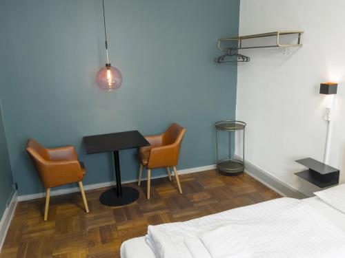 a bedroom with a table and two chairs and a bed at where to sleep in Copenhagen
